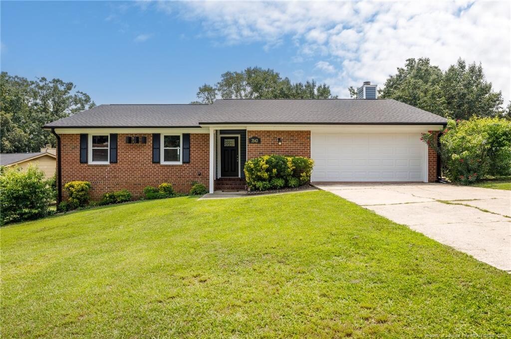 3543 Barron Way, Fayetteville, NC 28311 - single story home with a garage, brick siding, driveway, a front lawn, and a chimney