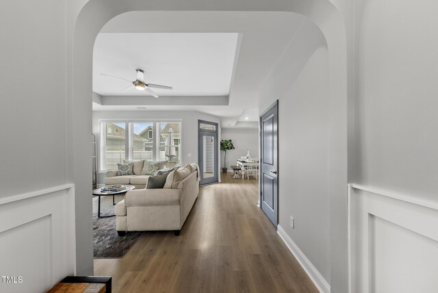 1727 Pinecliff Ct, Fuquay Varina, NC 27526 - hallway featuring arched walkways, wood finished floors, and a raised ceiling