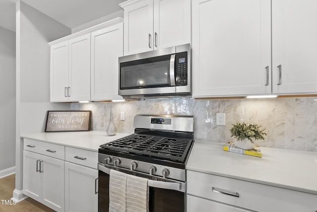 1727 Pinecliff Ct, Fuquay Varina, NC 27526 - kitchen with stainless steel appliances, light countertops, white cabinetry, light wood-style flooring, and backsplash