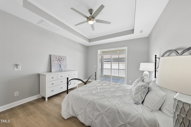 1727 Pinecliff Ct, Fuquay Varina, NC 27526 - bedroom featuring a tray ceiling, wood finished floors, access to exterior, and ceiling fan