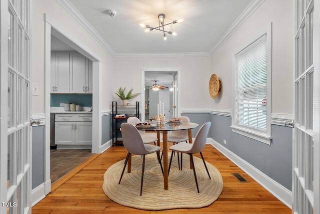 1826 Northgate St, Durham, NC 27704 - dining area featuring light wood-style floors, crown molding, a chandelier, ceiling fan, and baseboards