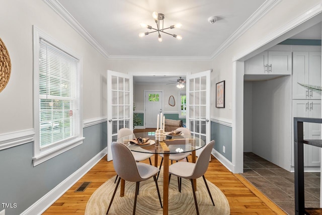 1826 Northgate St, Durham, NC 27704 - dining area featuring light wood-style flooring, french doors, crown molding, and a chandelier