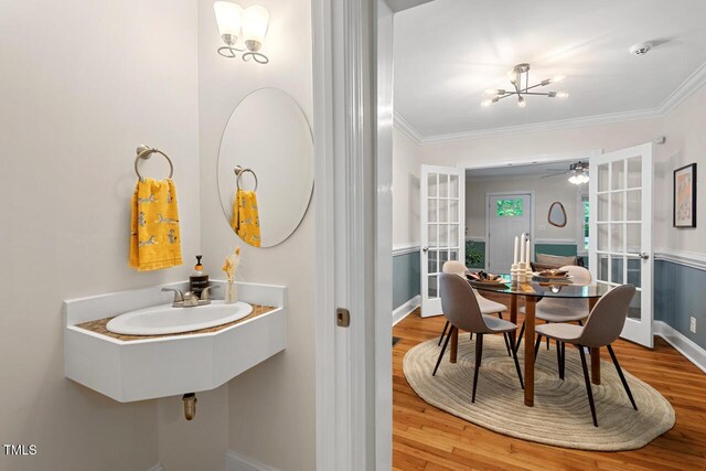 1826 Northgate St, Durham, NC 27704 - bathroom featuring a sink, a chandelier, wood finished floors, ornamental molding, and baseboards