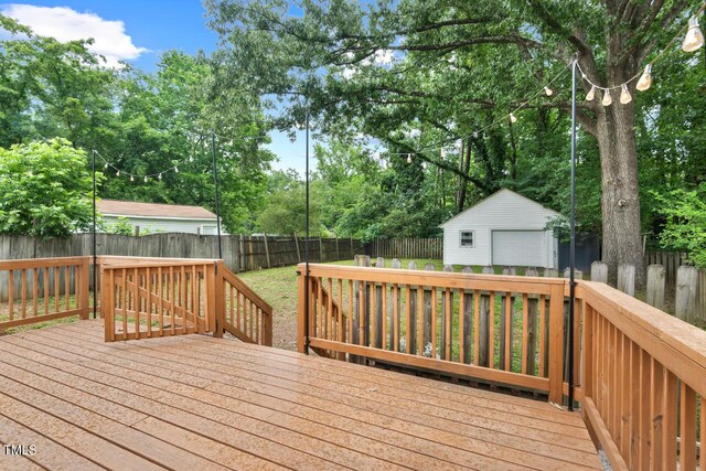 1826 Northgate St, Durham, NC 27704 - wooden terrace with a detached garage, a fenced backyard, an outbuilding, and view of scattered trees