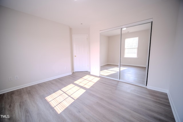 8021 Wesley Farm Dr, Raleigh, NC 27616 - unfurnished bedroom with wood finished floors, baseboards, and a closet