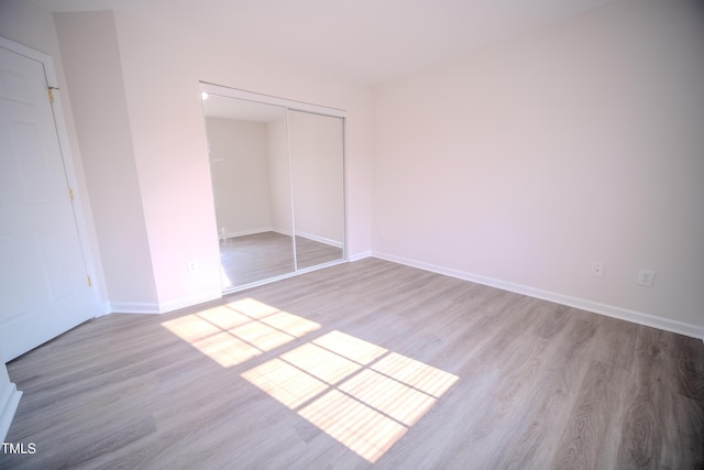 8021 Wesley Farm Dr, Raleigh, NC 27616 - unfurnished bedroom featuring wood finished floors, a closet, and baseboards