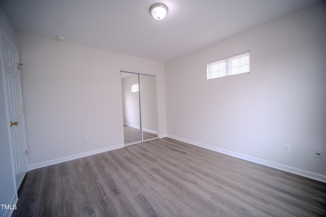 8021 Wesley Farm Dr, Raleigh, NC 27616 - unfurnished bedroom featuring wood finished floors, baseboards, and a closet