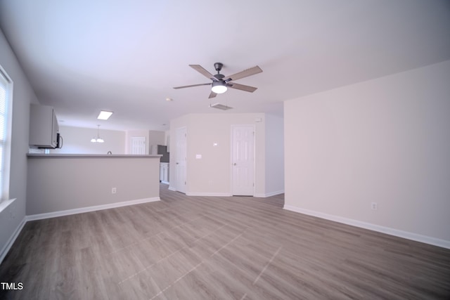 8021 Wesley Farm Dr, Raleigh, NC 27616 - unfurnished living room with a ceiling fan and baseboards