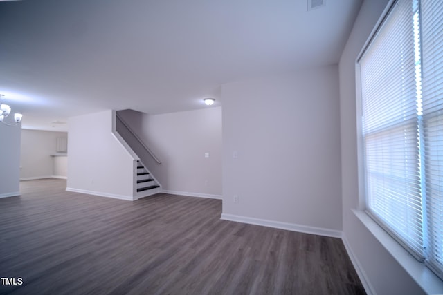 8021 Wesley Farm Dr, Raleigh, NC 27616 - unfurnished living room featuring stairway, dark wood-style floors, baseboards, and a chandelier