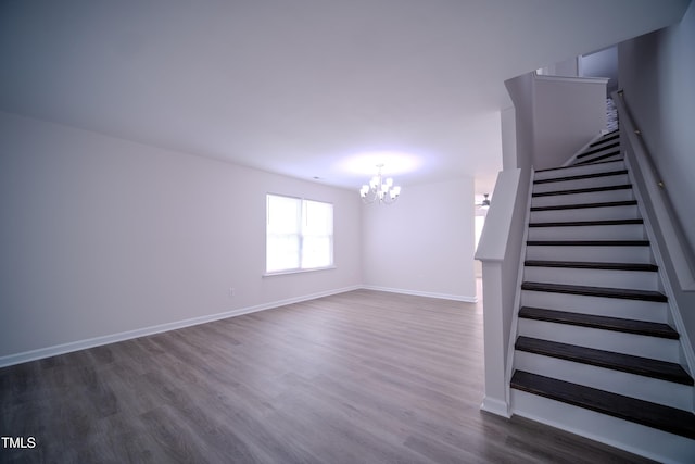 8021 Wesley Farm Dr, Raleigh, NC 27616 - unfurnished living room with a chandelier, stairs, dark wood-type flooring, and baseboards