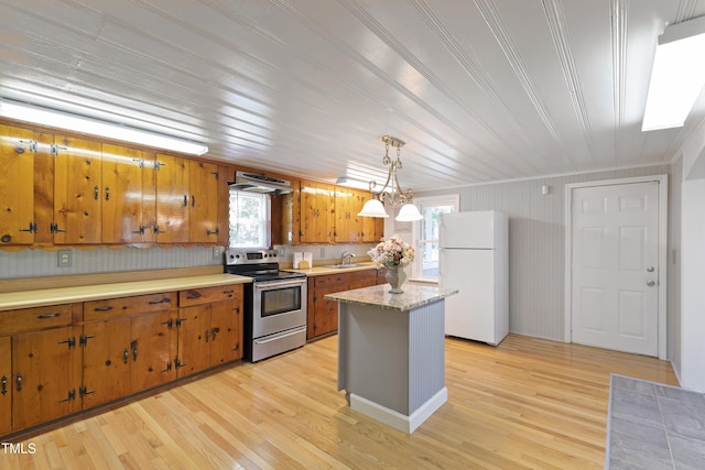 803 Hare St, Selma, NC 27576 - kitchen with stainless steel range with electric cooktop, freestanding refrigerator, brown cabinets, under cabinet range hood, and light countertops