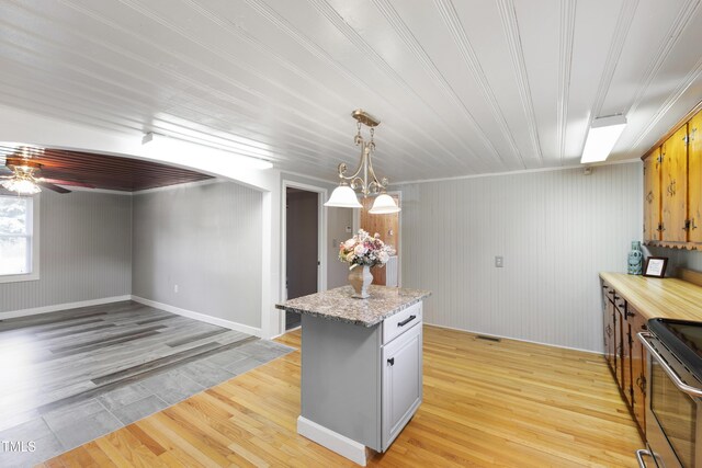 803 Hare St, Selma, NC 27576 - kitchen featuring stainless steel range with electric stovetop, light wood-style flooring, ceiling fan, and a kitchen island