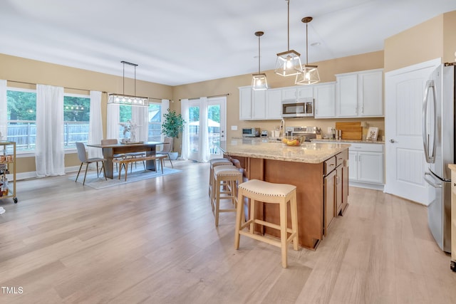 2310 Turning Pointe Way, Hillsborough, NC 27278 - kitchen with stainless steel appliances, light wood-style floors, a kitchen island, and white cabinetry