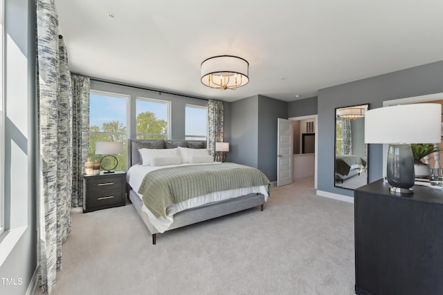 144 N White St # 100, Wake Forest, NC 27587 - bedroom with light colored carpet, baseboards, and a chandelier