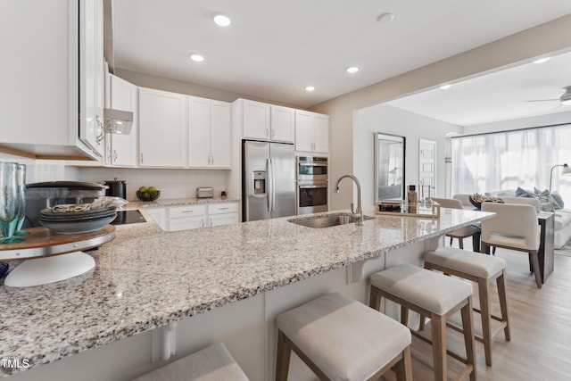 144 N White St # 100, Wake Forest, NC 27587 - kitchen featuring stainless steel appliances, a sink, light stone counters, a kitchen bar, and backsplash