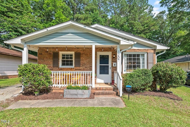 1207 Grant St, Durham, NC 27701 - view of front of property with covered porch, a front lawn, and brick siding