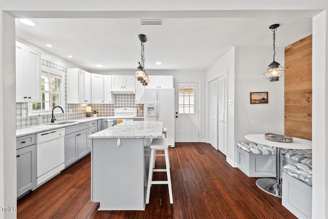 1207 Grant St, Durham, NC 27701 - kitchen with white appliances, a sink, backsplash, a center island, and light stone counters