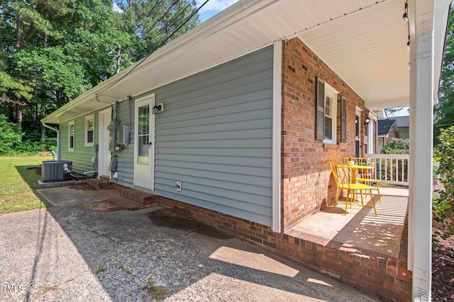 1207 Grant St, Durham, NC 27701 - view of side of property with entry steps, a porch, brick siding, and central AC