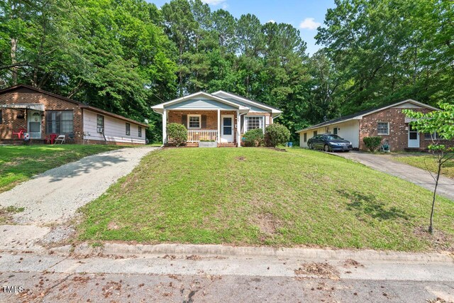 1207 Grant St, Durham, NC 27701 - view of front of house featuring a porch, driveway, a front yard, and brick siding