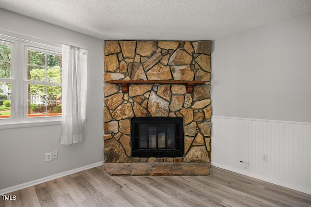 7731 Kingsberry Ct, Raleigh, NC 27615 - detailed view of wood finished floors, a fireplace, a textured ceiling, and wainscoting