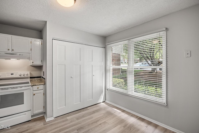 7731 Kingsberry Ct, Raleigh, NC 27615 - kitchen featuring white electric range oven, under cabinet range hood, a textured ceiling, light wood-style floors, and white cabinets