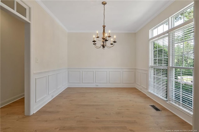 196 Leaning Pine Cir, Spring Lake, NC 28390 - empty room featuring a chandelier, ornamental molding, light wood-style floors, and a wainscoted wall
