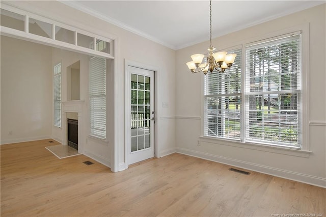 196 Leaning Pine Cir, Spring Lake, NC 28390 - unfurnished dining area featuring a chandelier, healthy amount of natural light, light wood-style flooring, and crown molding