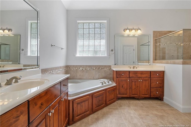 196 Leaning Pine Cir, Spring Lake, NC 28390 - bathroom featuring two vanities, a shower stall, a garden tub, and tile patterned flooring