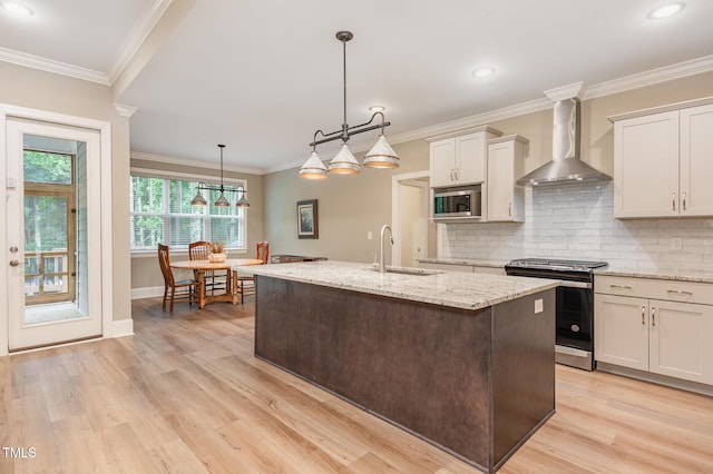 40 Yellowstone Ct, Youngsville, NC 27596 - kitchen with appliances with stainless steel finishes, wall chimney range hood, light wood finished floors, a sink, and tasteful backsplash