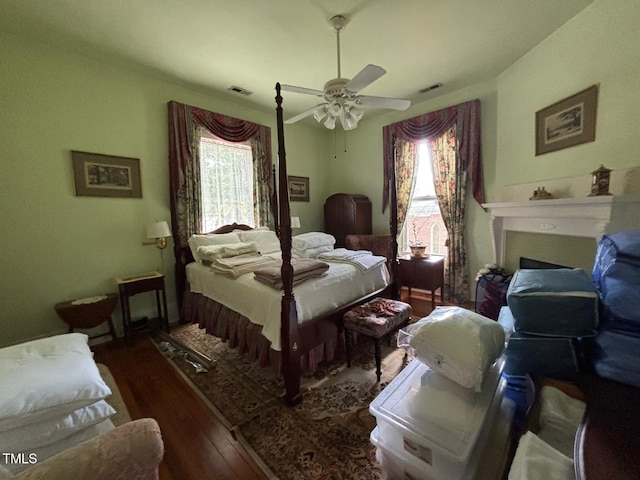331 N Main St, Warrenton, NC 27589 - bedroom with wood-type flooring, a ceiling fan, and a fireplace