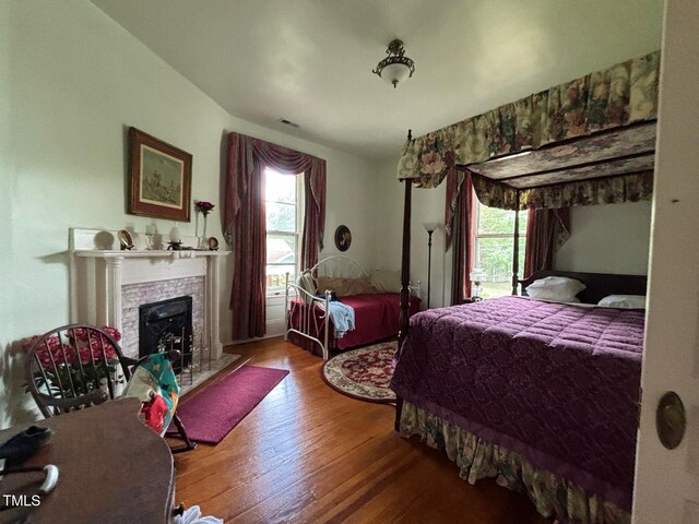 331 N Main St, Warrenton, NC 27589 - bedroom with a tile fireplace, hardwood / wood-style flooring, and multiple windows