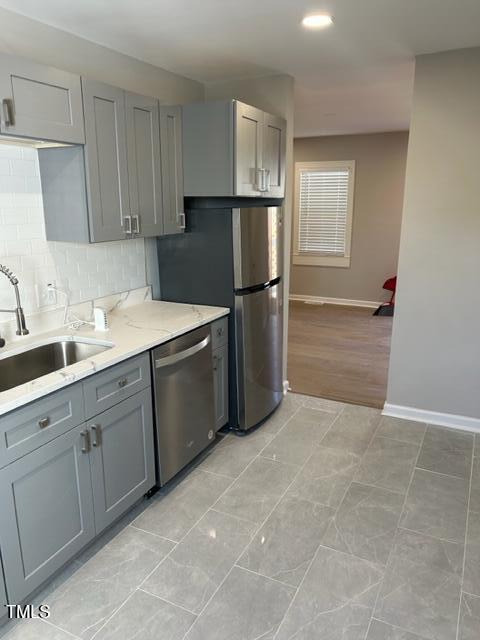 407 Bledsoe Ave, Raleigh, NC 27601 - kitchen featuring stainless steel dishwasher, gray cabinetry, tasteful backsplash, and light stone countertops