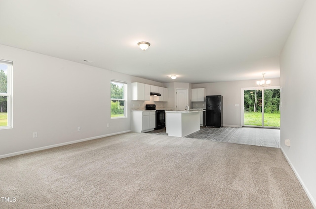 6044 Lowgrass Rd, Stedman, NC 28391 - unfurnished living room with a chandelier, light carpet, baseboards, and a sink