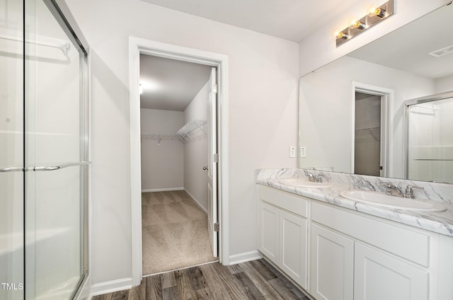6044 Lowgrass Rd, Stedman, NC 28391 - full bath with a spacious closet, a shower stall, double vanity, wood finished floors, and baseboards