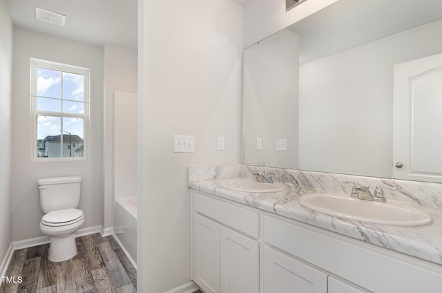 6044 Lowgrass Rd, Stedman, NC 28391 - bathroom with double vanity, toilet, wood finished floors, and baseboards