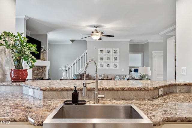 9300 Lake Wheeler Rd, Fuquay Varina, NC 27526 - kitchen featuring a sink, ceiling fan, crown molding, open floor plan, and light stone countertops