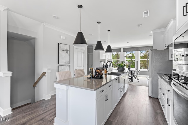 659 Bandon Aly, Cary, NC 27513 - kitchen with stainless steel oven, a sink, dark wood finished floors, an island with sink, and white cabinets