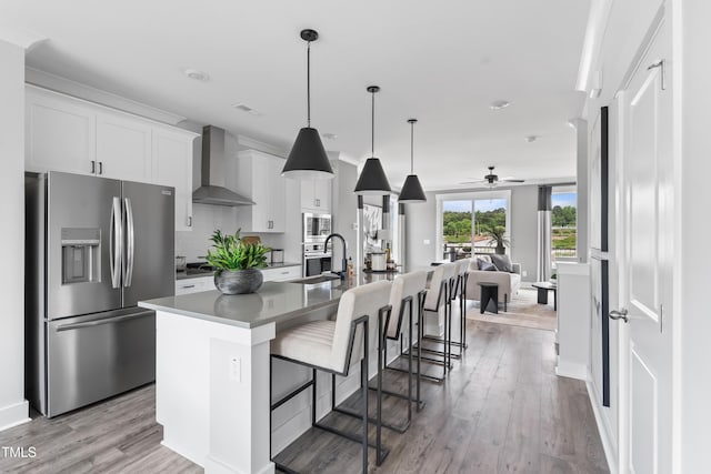 659 Bandon Aly, Cary, NC 27513 - kitchen with appliances with stainless steel finishes, wall chimney range hood, open floor plan, and light wood finished floors