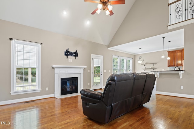 37 Meadow Oaks Cir, Smithfield, NC 27577 - living area featuring a ceiling fan, wood finished floors, baseboards, a fireplace with flush hearth, and high vaulted ceiling