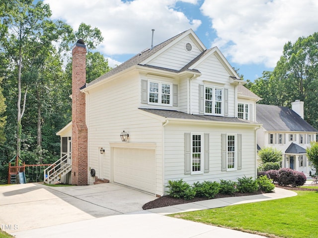 305 Promontory Point Dr, Cary, NC 27513 - view of front of house featuring a garage, concrete driveway, a chimney, and a front yard