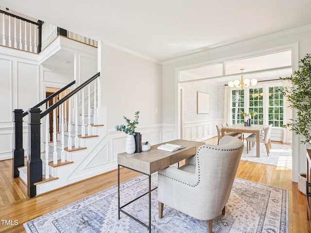 305 Promontory Point Dr, Cary, NC 27513 - home office featuring a decorative wall, a chandelier, light wood-style floors, crown molding, and wainscoting