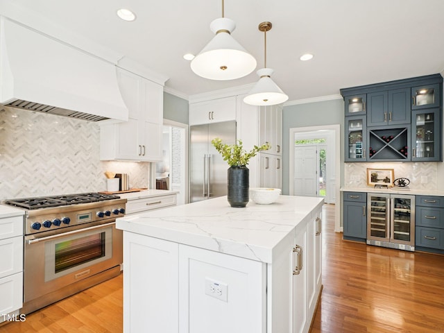 305 Promontory Point Dr, Cary, NC 27513 - kitchen featuring premium appliances, wine cooler, custom exhaust hood, decorative backsplash, and ornamental molding