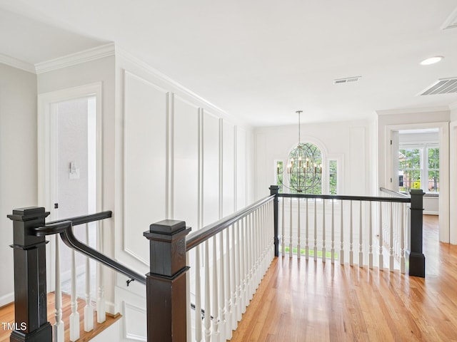 305 Promontory Point Dr, Cary, NC 27513 - hall with an upstairs landing, light wood finished floors, a chandelier, and crown molding