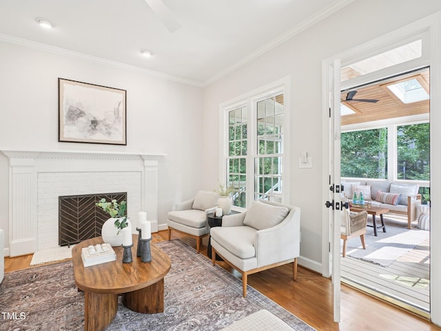 305 Promontory Point Dr, Cary, NC 27513 - living room featuring a ceiling fan, wood finished floors, ornamental molding, plenty of natural light, and a fireplace