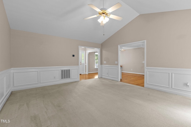 304 Foxcroft Dr, Timberlake, NC 27583 - empty room with light carpet, wainscoting, a decorative wall, vaulted ceiling, and a ceiling fan