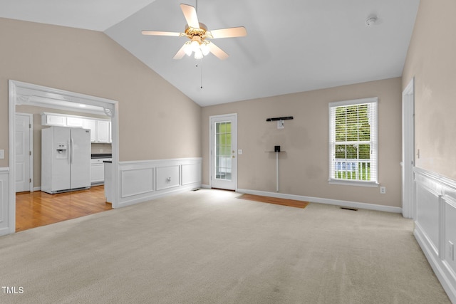 304 Foxcroft Dr, Timberlake, NC 27583 - unfurnished living room with light colored carpet, vaulted ceiling, ceiling fan, plenty of natural light, and wainscoting