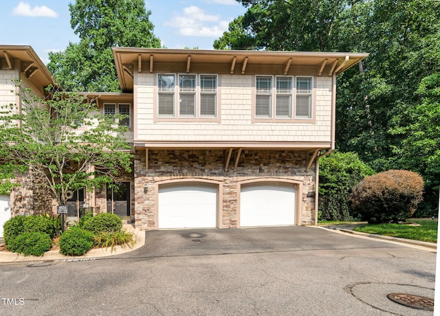 4831 Crestmore Rd Unit 202, Raleigh, NC 27612 - view of front of property with stone siding, asphalt driveway, and a garage