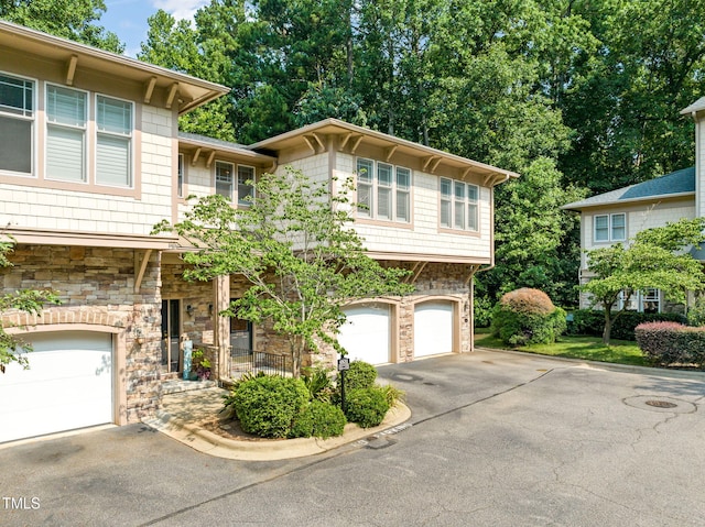 4831 Crestmore Rd Unit 202, Raleigh, NC 27612 - view of front of house with stone siding, asphalt driveway, and an attached garage