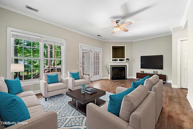 2623 Broad Oaks Pl, Raleigh, NC 27603 - living area with a ceiling fan, crown molding, wood finished floors, baseboards, and a glass covered fireplace