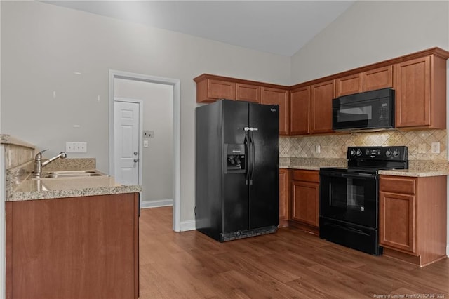 267 Driftwood Ln, Raeford, NC 28376 - kitchen with black appliances, a sink, tasteful backsplash, vaulted ceiling, and dark wood-style floors